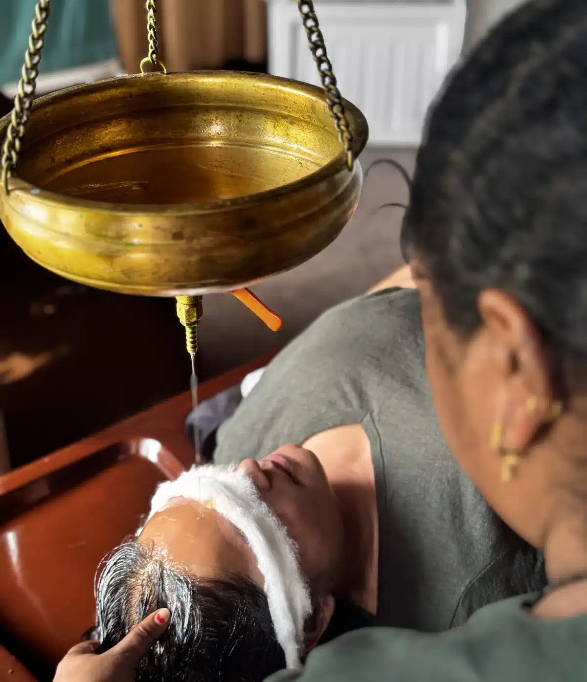 Close view of Shirodhara oil flow during Ayurvedic therapy at Yan Cure
